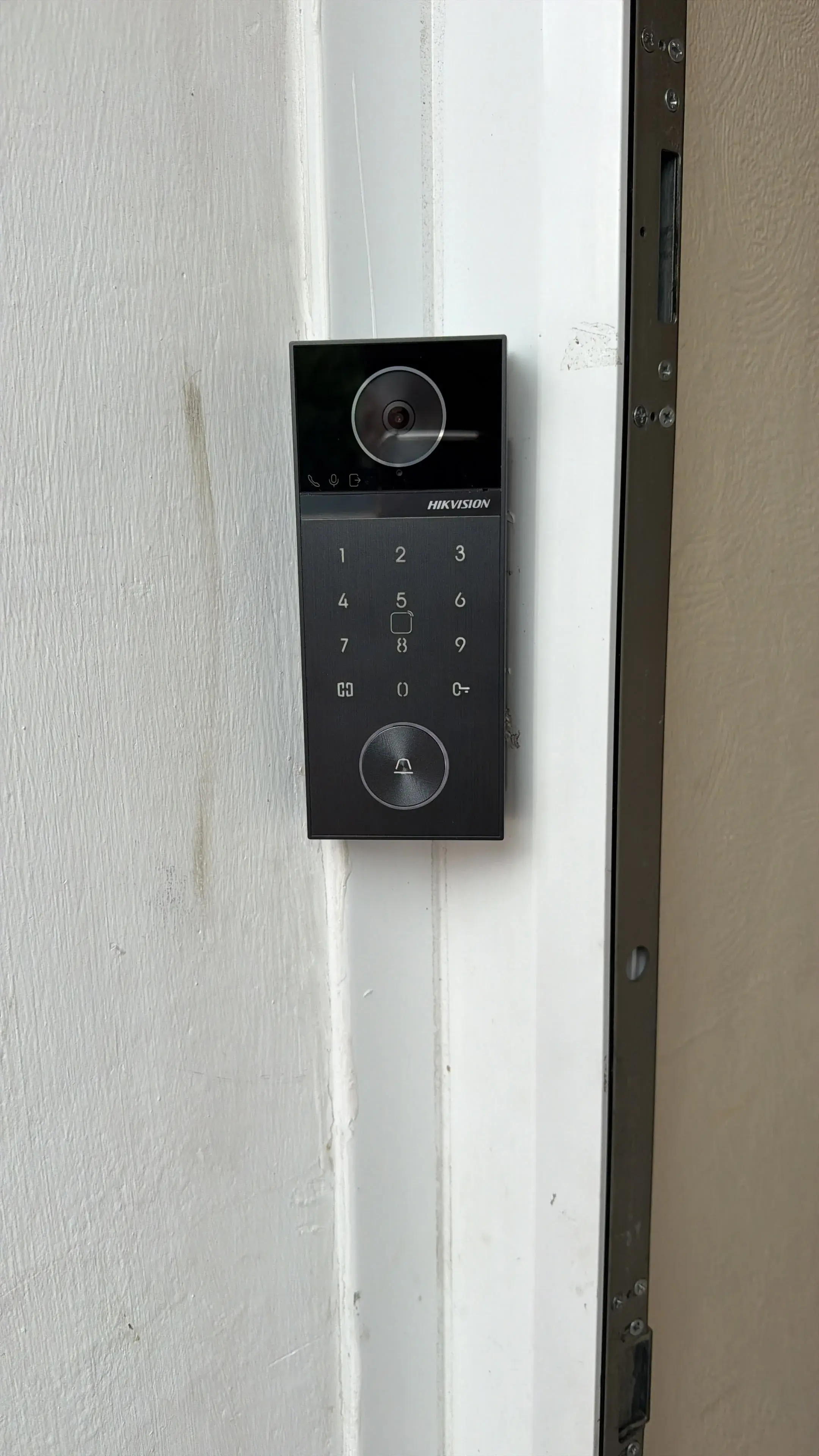 Hikvision keypad video intercom door entry system beside a front door